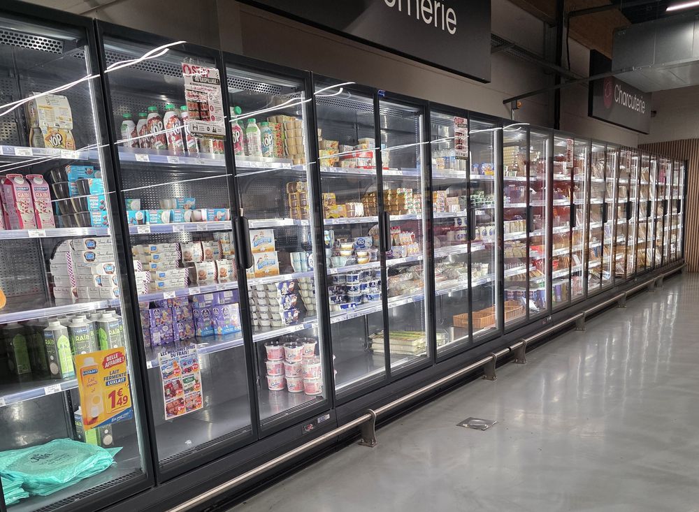 Rayon crèmerie : longue rangée de meubles réfrigérés à portes vitrées