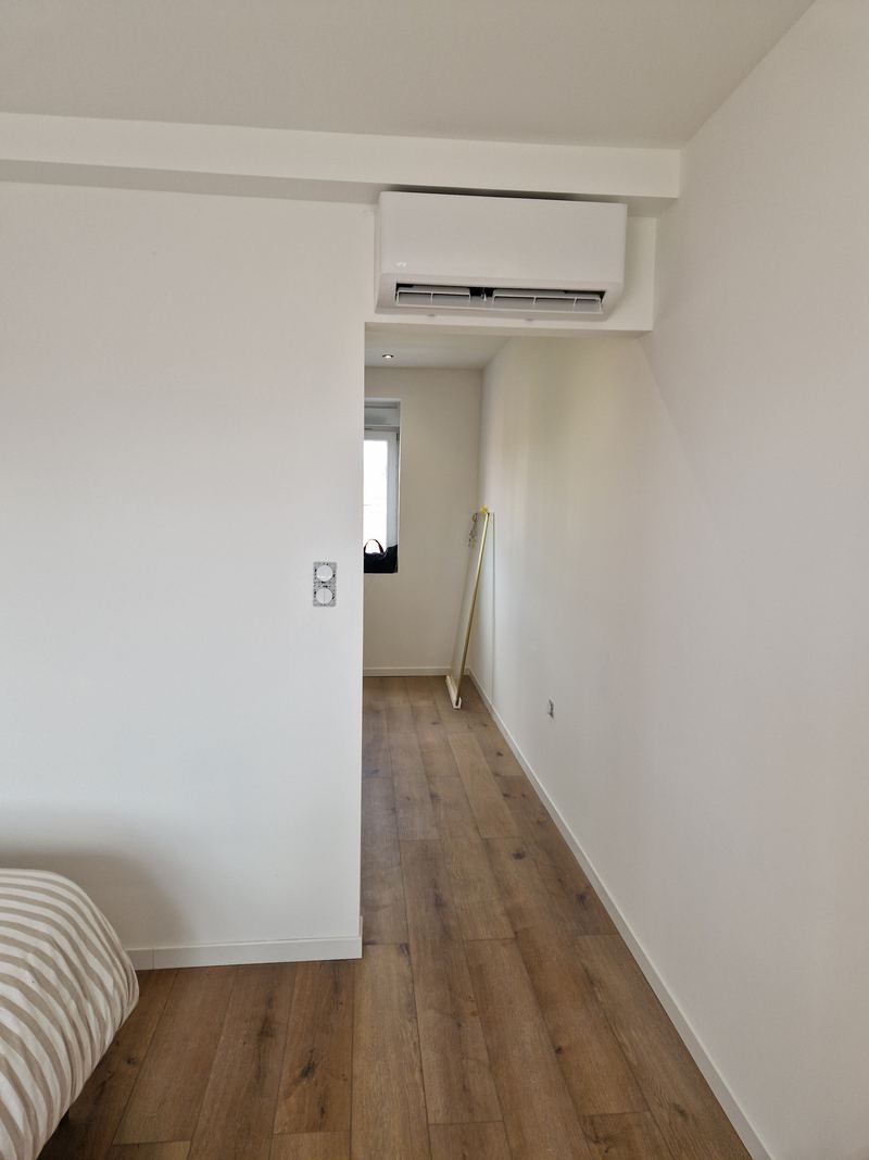 Climatiseur mural dans une chambre aux murs blancs