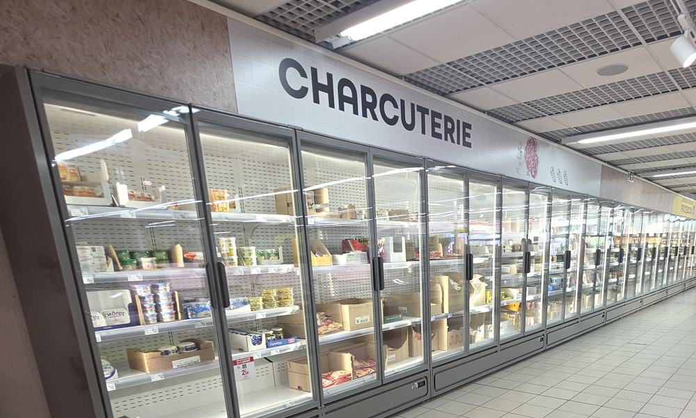 Rayon charcuterie : mur de meubles réfrigérés à portes vitrées dans un supermarché